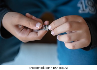 Hands of the child with nail clipper, clipping the nails on his own - Shutterstock ID 1094683172