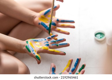 Hands Of A Child In Paint. Kids Hands Covered With Paint Top View.  Teacher Works With Children According To The Montessori Method And Paints Their Hands. 