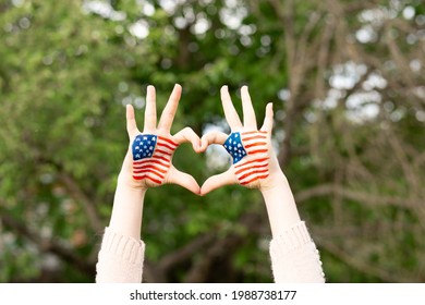 Hands of child painted in American flag color in heart shape. Patriotic holiday. Independence Day, Flag Day, 4th July, 14 June. Little girl show love gesture with hands with USA flag. 