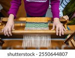 Hands of child weaving on loom with joy of crafting. Weaving as hobby for fine motor skill improvement, imaginative, skillful handwork. Creative handmade activity in traditional crafts for kids.