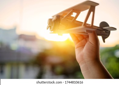 Hands Of Children Holding A Toy Plane And Have Dreams Wants To Be A Pilot. Toy Balsa Wood Airplane In The Sky, Independence In Learning And Adventure Concept