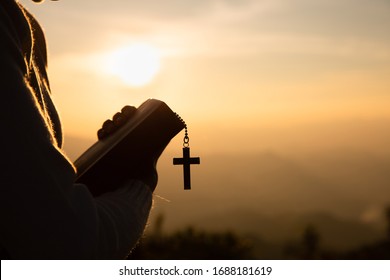 Hands of a Christian man holding a bible while praying to God, Religious beliefs, Copy space.