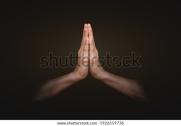 Hands clasped. Man hands\
in praying position on black background. Faith in religion and\
belief in God .