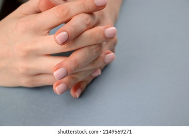 Hands clasped together for a prayer, waiting gesture, negotiations. Caucasian female woman clasping hands with perfect pink manicure.