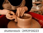 Hands, clay and pottery wheel with skills for craft, tools or sustainable production at small business. Person, artist and entrepreneur for eco friendly material, sculpture or manufacturing in studio