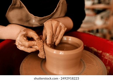 Hands, clay and pottery wheel with skills for craft, tools or sustainable production at small business. Person, artist and entrepreneur for eco friendly material, sculpture or manufacturing in studio - Powered by Shutterstock