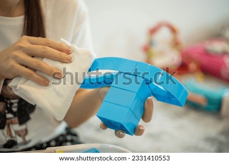 Hands cleaning with alchohol to disinfecting toys.
