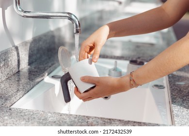 Hands Cleaning An Italian Moka Coffee Maker In The Sink After Having Used It.