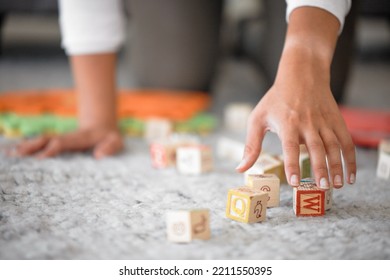 Hands, cleaning and toys with a woman or mother picking up building blocks in the house to clean or tidy. Hand, responsible and object with a female cleaner working on a home floor for housework - Shutterstock ID 2211550395