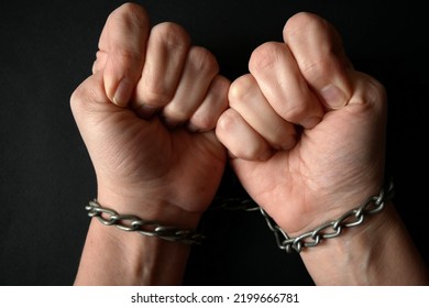 Hands Clenched Into Fists In Chains On A Black Background, The Problem Of Slavery And Violence Concept, Juneteenth Freedom Breaking Chains Closeup