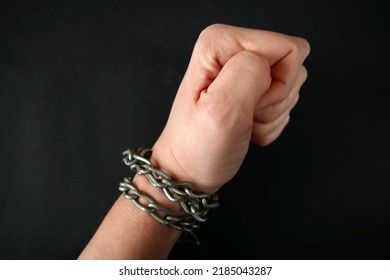 Hands Clenched Into Fists In Handcuffs In The Form Of Chains On A Black Background, The Problem Of Slavery And Violence Concept, Juneteenth Freedom Breaking Chains 