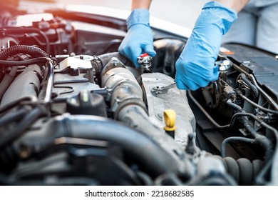 Hands Close Up Of A Smiling Young Female Mechanic Performing Diagnostics On A Car In An Auto Repair Shop. Woman Mechanic. Woman's Hands Under The Hood