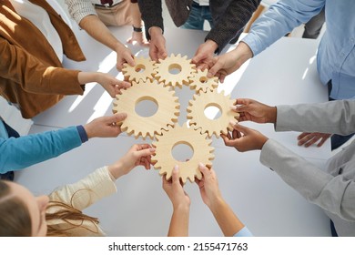 Hands Close-up Of Group Multiethnic Business People Connect Wooden Gears In The Center. Arial View. Success Cooperation Teamwork Concept, Connection Technology Concept