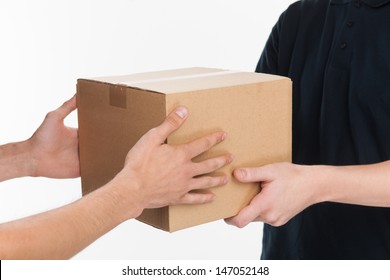 From Hands To Hands. Close-up Of Hands Holding Cardboard Box While Isolated On White