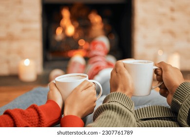 Hands, coffee and couple relax by fireplace, bonding and cozy in home together. Tea, man and woman relaxing by fire on Christmas holiday in winter, heat and enjoying quality time with drinks in house - Powered by Shutterstock