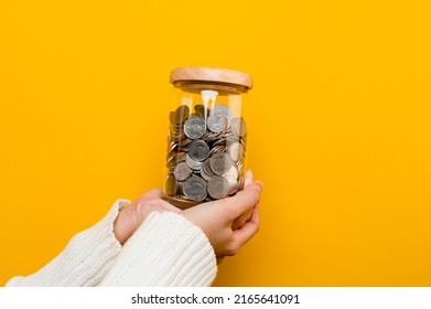 Hands and coins in a savings jar money saving on yellow background money saving concept Plant a plan to save money for children. - Shutterstock ID 2165641091