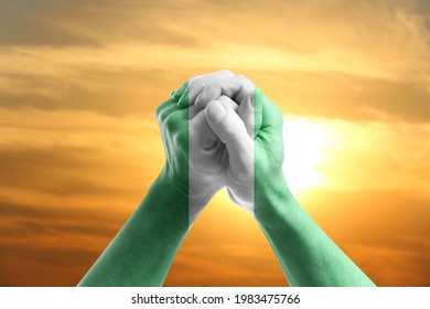 Hands in colors of Nigerian flag at sunrise