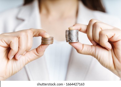 Hands Compare Two Piles Of Coins Of Different Sizes.