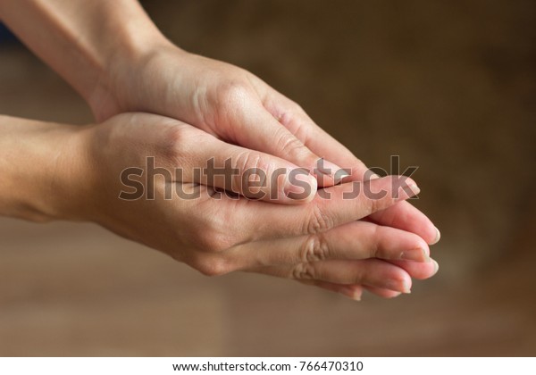 Hands are connected close-up. A gesture of\
help, supplication,\
repentance.