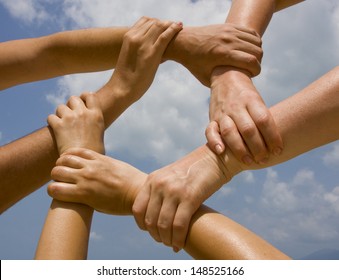 Hands Connecting To A Chain With Blue Sky