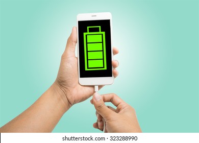 Hands connecting smartphone with low battery to a charger - Powered by Shutterstock