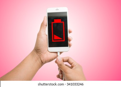 Hands Connecting Smartphone With Low Battery To A Charger