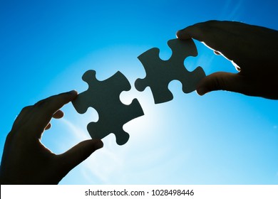 Hands Connecting Two Puzzle Pieces. 