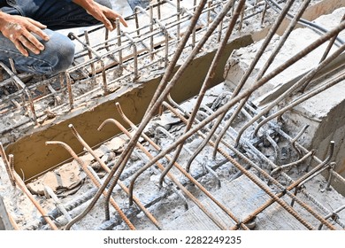 The hands of construction workers using checking steel wire to bind steel bars. - Shutterstock ID 2282249235