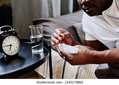 Hands of contemporary senior black man holding long plastic container with pills while taking medicaments after sleep in the morning - Powered by Shutterstock