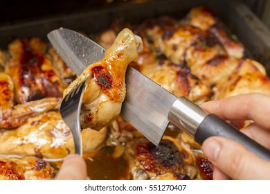 Hands Of The Cook With A Knife And Fork. Cooking Chicken In The Oven. The Cook Prepares Chicken Meat. Roasted Meat Of A Hen. The Process Of Cooking Meat In The Oven.