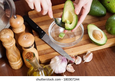 Hands Cooking With Avocado At Table In Home Kitchen