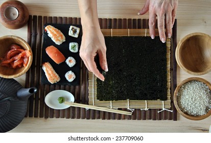 Hands Cooking Sushi With Rice, Salmon And Nori