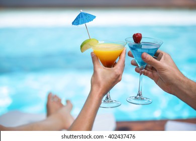 Hands of couple toasting martini glass near pool - Powered by Shutterstock