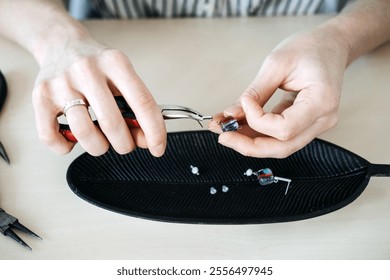 Hands crafting handmade jewelry with pliers and beads. Capturing artisan workspace and the creative jewelry-making process. - Powered by Shutterstock