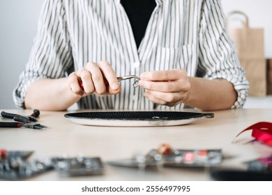 Hands crafting handmade jewelry with pliers and beads. Capturing artisan workspace and the creative jewelry-making process. - Powered by Shutterstock