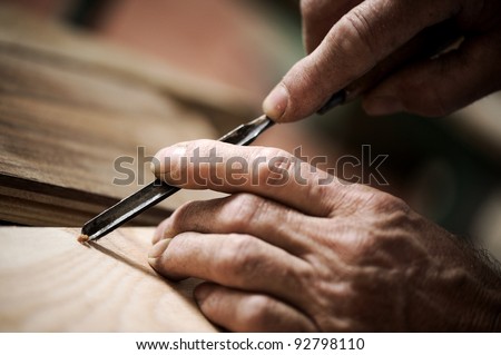 hands of the craftsman carve a bas-relief with a gouge