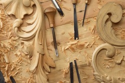 Hands Of Craftsman Carve With A Gouge In The Hands On The Workbench In Carpentry. Wood Carving Tools Close-up Top View.