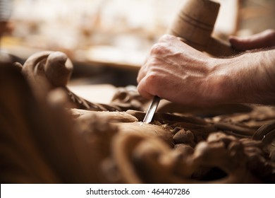 Hands of craftsman carve  with a gouge in the hands on the workbench in carpentry