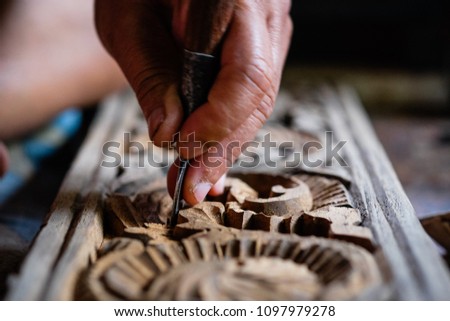 Hands of craftsman carve with a carve tools in the hands.Traditional craftsman carving wood.Thailand