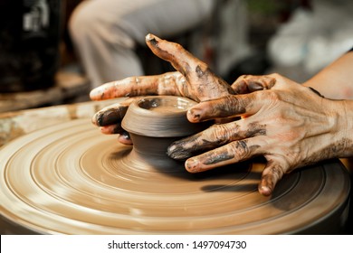 Hands of craftsman is molding clay on the pottery wheel. Ceramic craft. Self development skills concept. Artistic creative. Selective focus. - Powered by Shutterstock