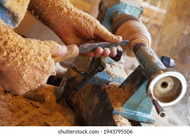 The Hands Of Craftsman Working On Wooden Vessel On Lathe. Working Environment, Shavings On Clothes And Hands. Small Business, Workshop For The Production Of Wooden Dishes. Shallow Depth Of Field