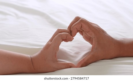 Couple’s hands create a heart shape, expressing romance and togetherness. This image reflects affection, trust, emotional bonding, partnership, and the beauty of shared moments.
