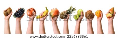 Hands of crop anonymous people holding various ripe fruits and berries on white background during harvesting season in light studio