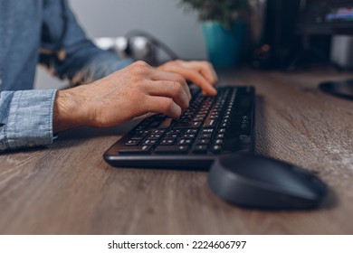 Hands of crop man typing on wireless computer keyboard while working at table in office  - Shutterstock ID 2224606797
