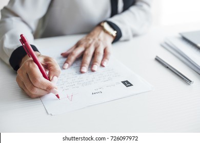 Hands of cropped woman teacher grading tests at school. - Shutterstock ID 726097972