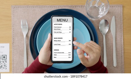Hand's customer scan QR code for online menu service at table in restaurant during pandemic coronavirus. New normal contactless technology lifestyle protection coronavirus pandemic in restaurant - Shutterstock ID 1891078417