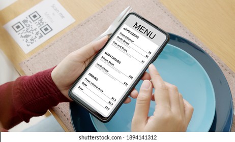 Hand's customer scan QR code for online menu service at table in restaurant during pandemic coronavirus. New normal contactless technology lifestyle protection coronavirus pandemic in restaurant - Shutterstock ID 1894141312