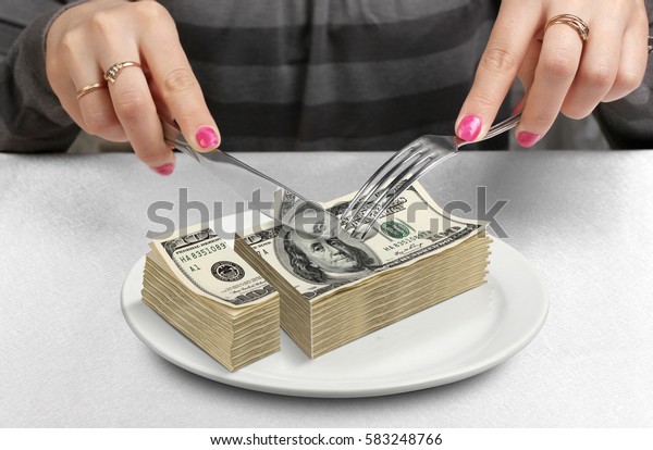 Hands cut money\
on plate, reduce funds\
concept