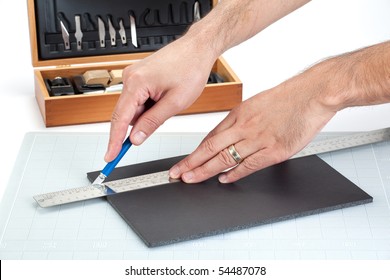 Hands cutting on board with sharp knife