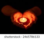 Hands, dark and person with candle, light and offering with religion on studio background. Closeup, model or human with open palms, solidarity or night with support, spiritual or ritual for vigil